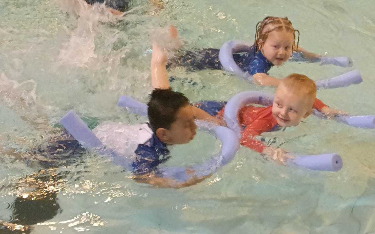 Mother and child in pool with instructor